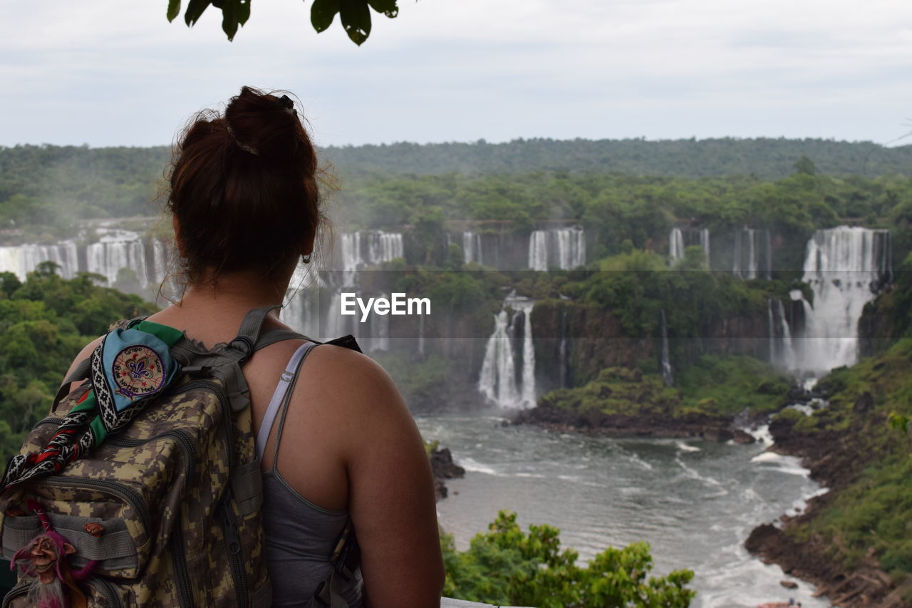 Rear view of woman looking at waterfall