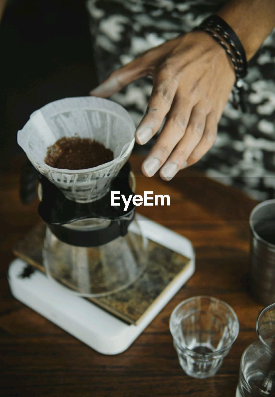 Cropped hand of person making coffee at home