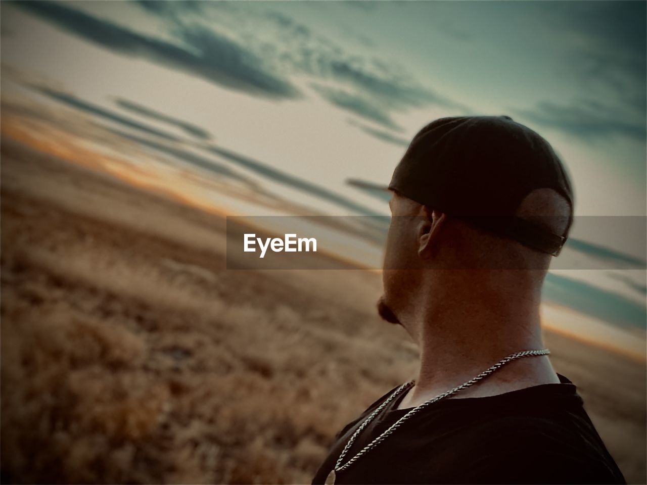 one person, adult, sky, black, nature, white, headshot, men, focus on foreground, land, person, portrait, light, rear view, clothing, sunlight, lifestyles, young adult, close-up, outdoors, sunset, darkness, cloud, looking, beach