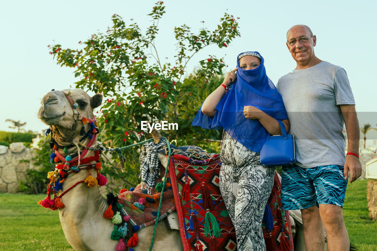 portrait of senior man with camel on field