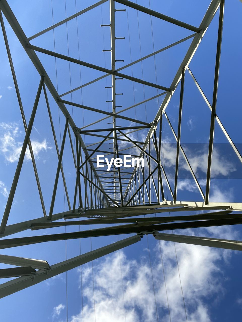 sky, cloud, technology, power generation, built structure, electricity, architecture, power supply, electricity pylon, tower, overhead power line, nature, blue, no people, line, cable, transmission tower, low angle view, communication, pattern, metal, outdoors, mast, girder, looking up, day, alloy, steel, industry, power line