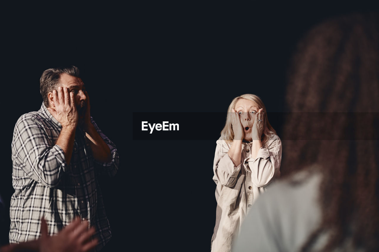 Male and female stage performers practicing emotions together in class