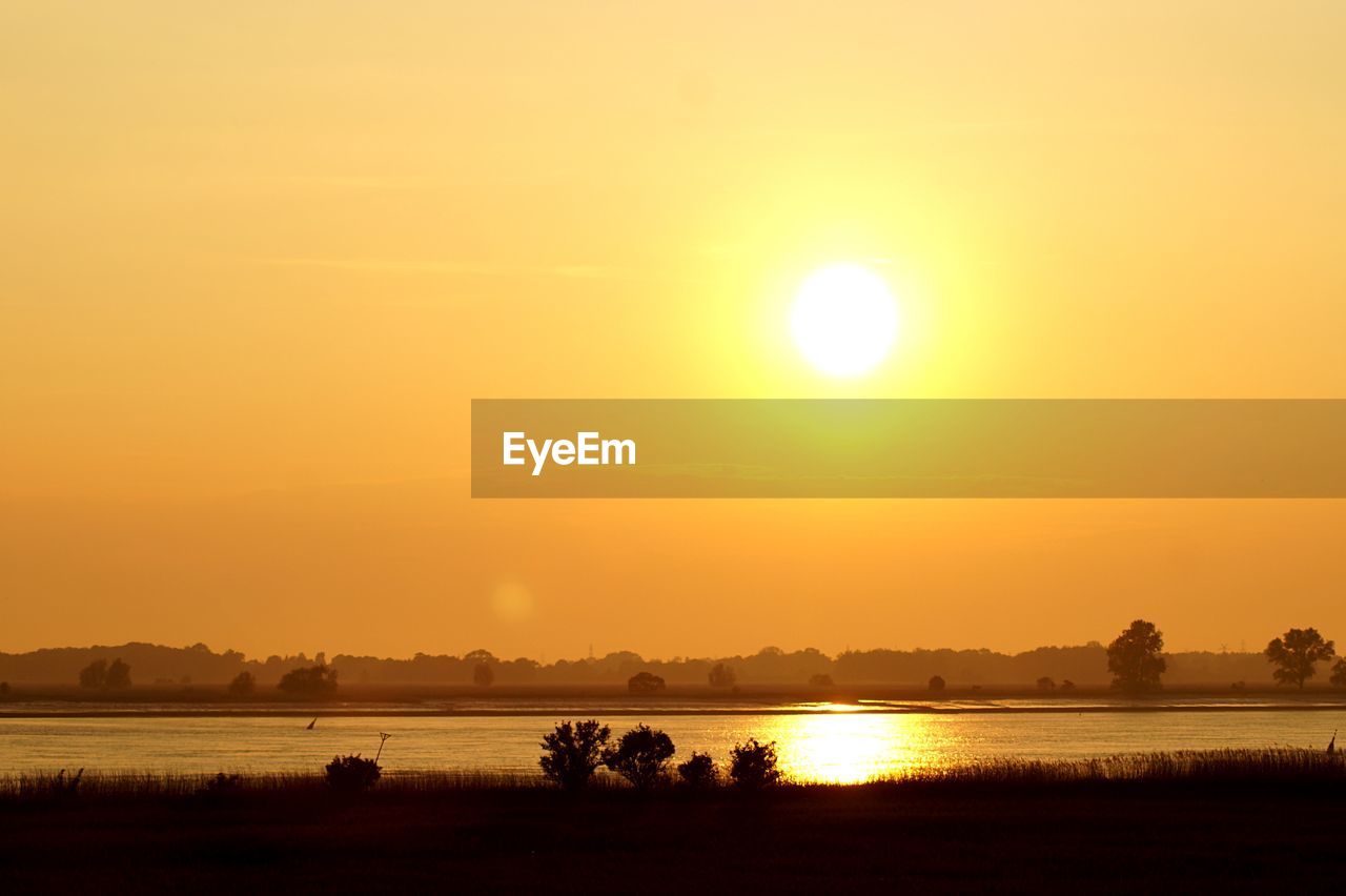 Scenic view of lake against romantic sky at sunset