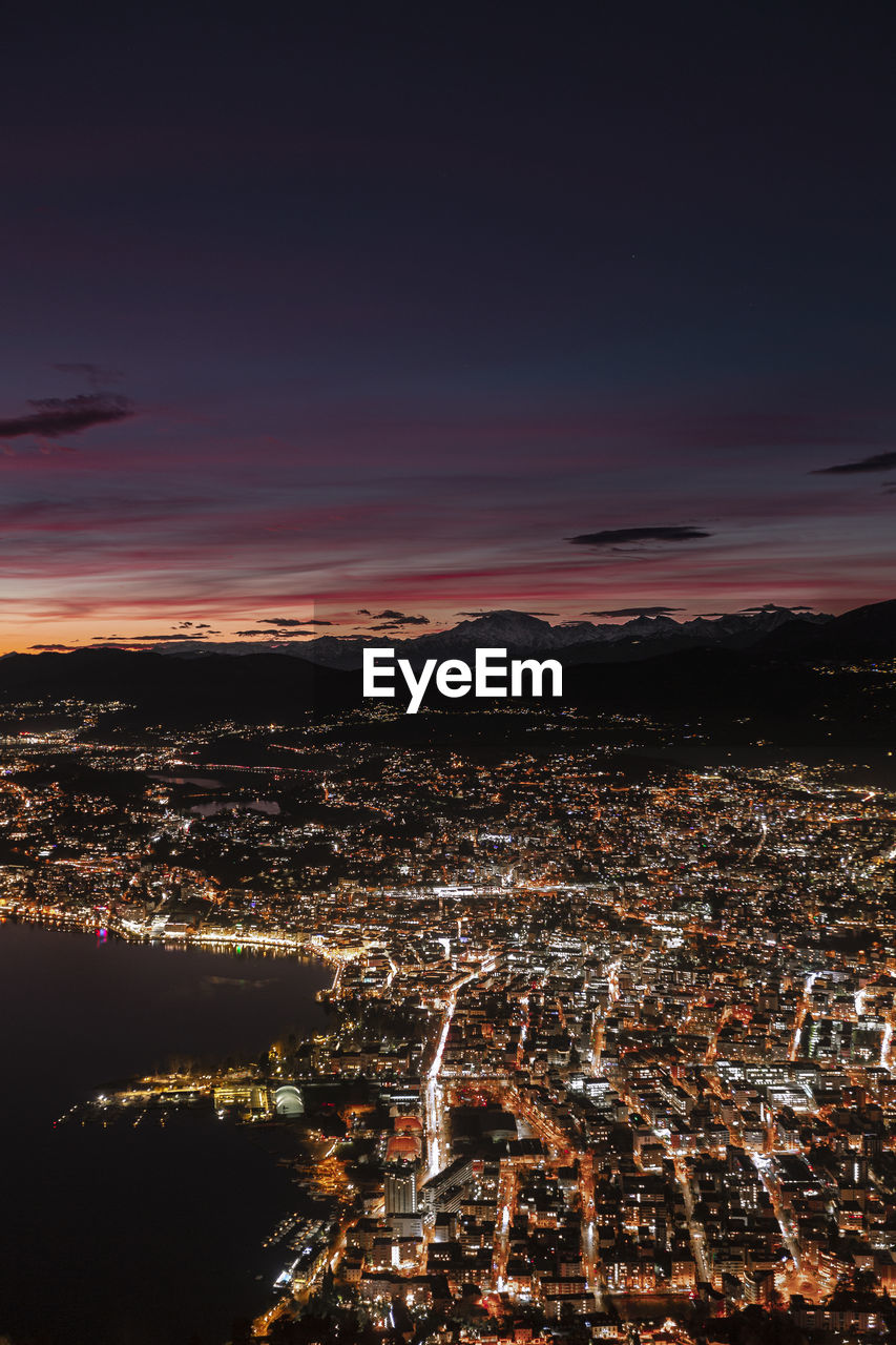 Aerial view of illuminated cityscape against sky at night