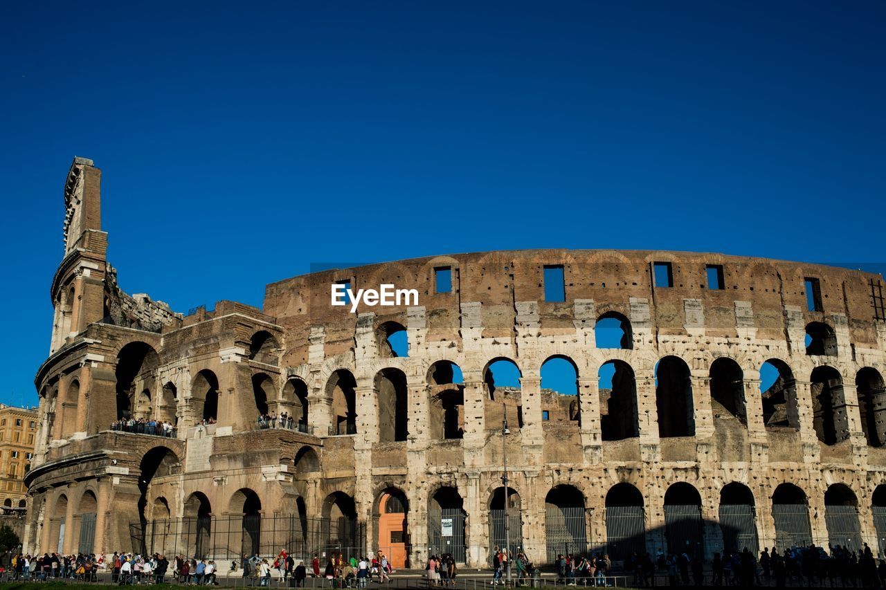 Coliseum against clear blue sky in city