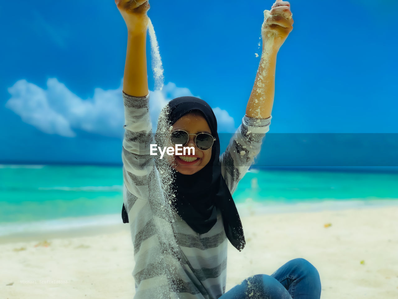 Portrait of young woman wearing sunglasses on beach