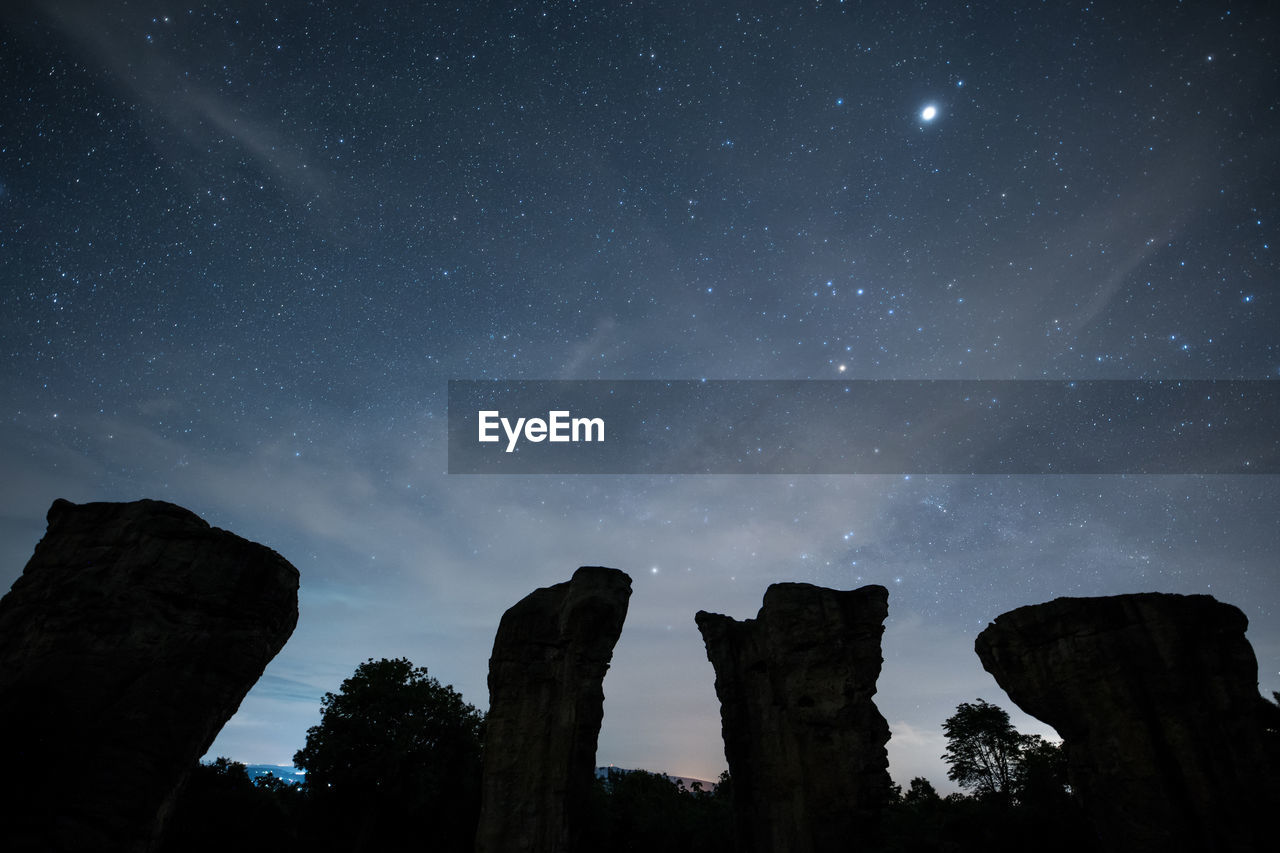 Low angle view of rocks against sky at night