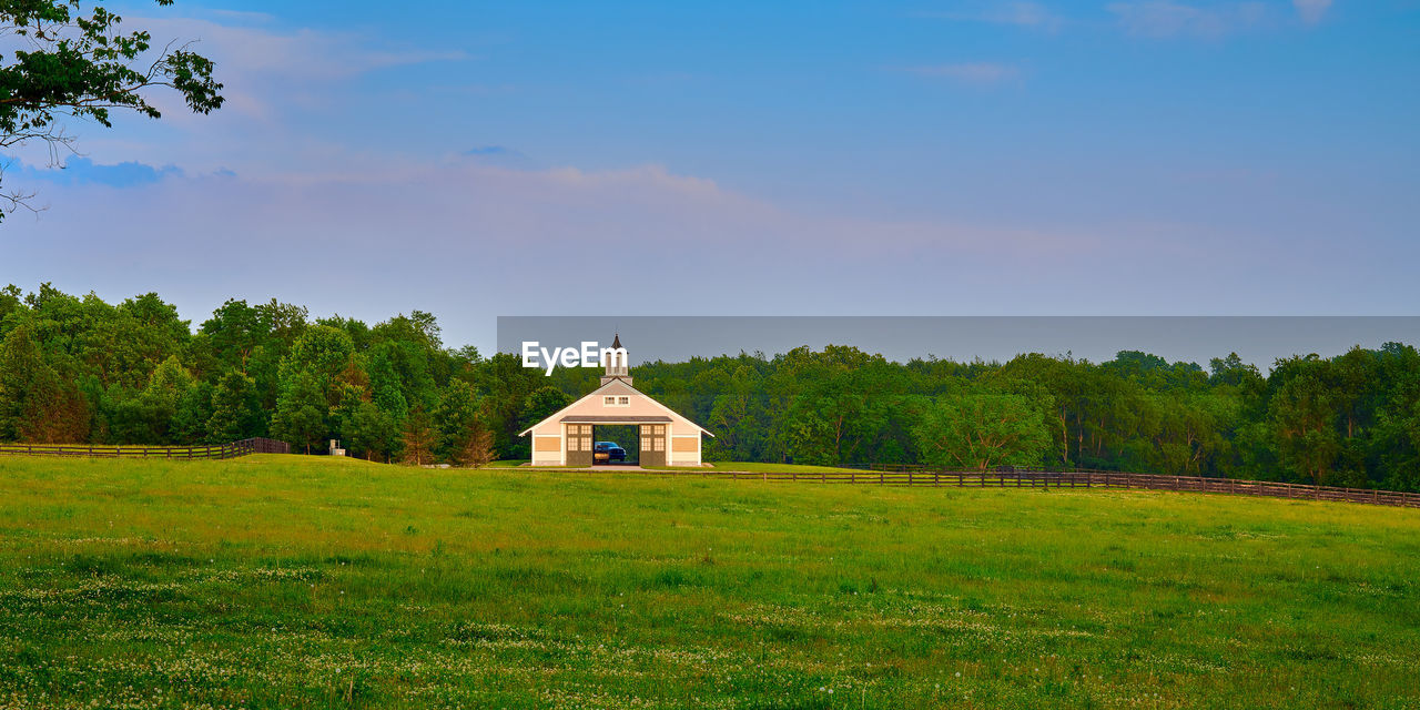 Kentucky horse barn with field in the foreground.