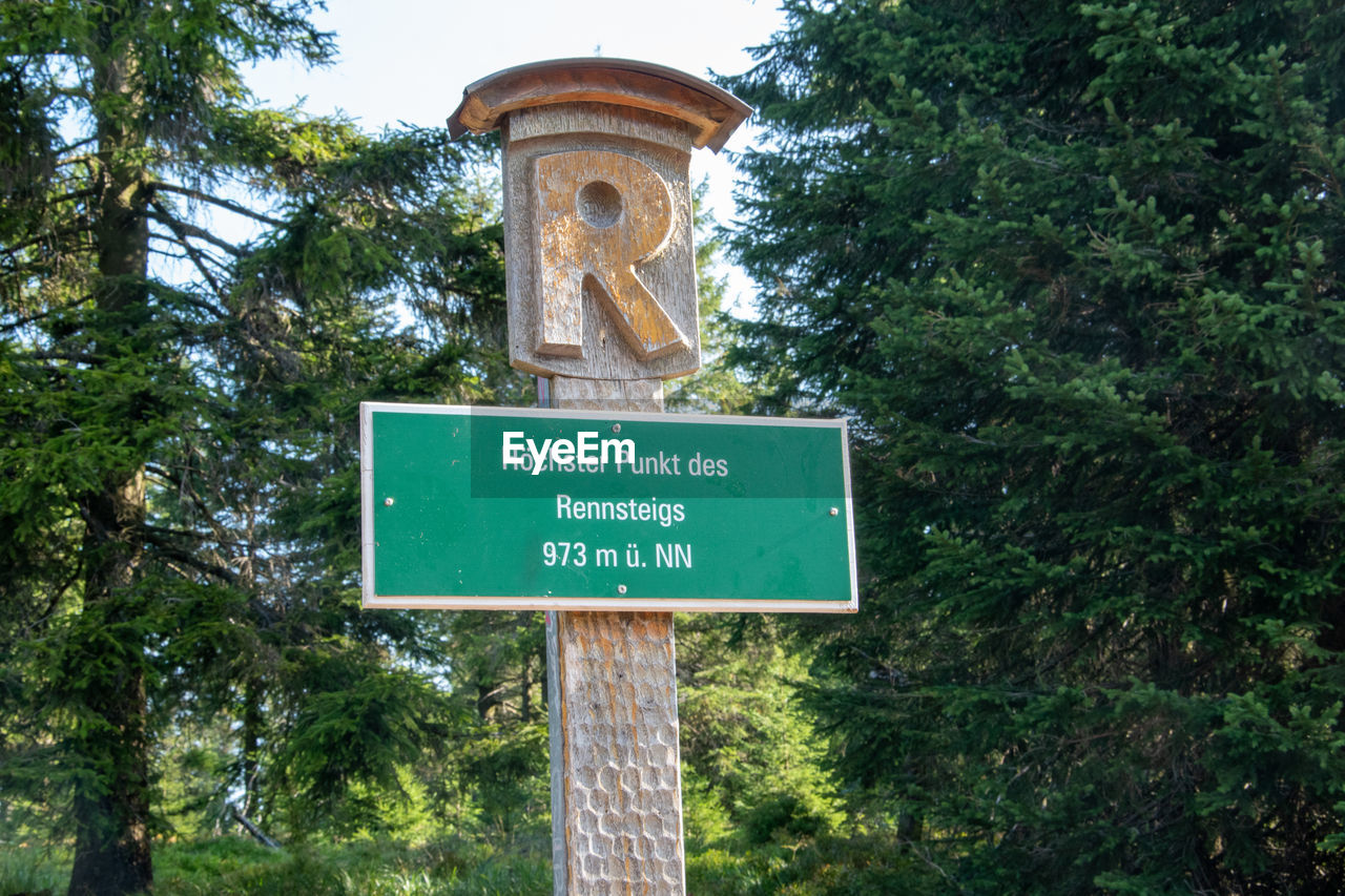 LOW ANGLE VIEW OF INFORMATION SIGN BY TREES