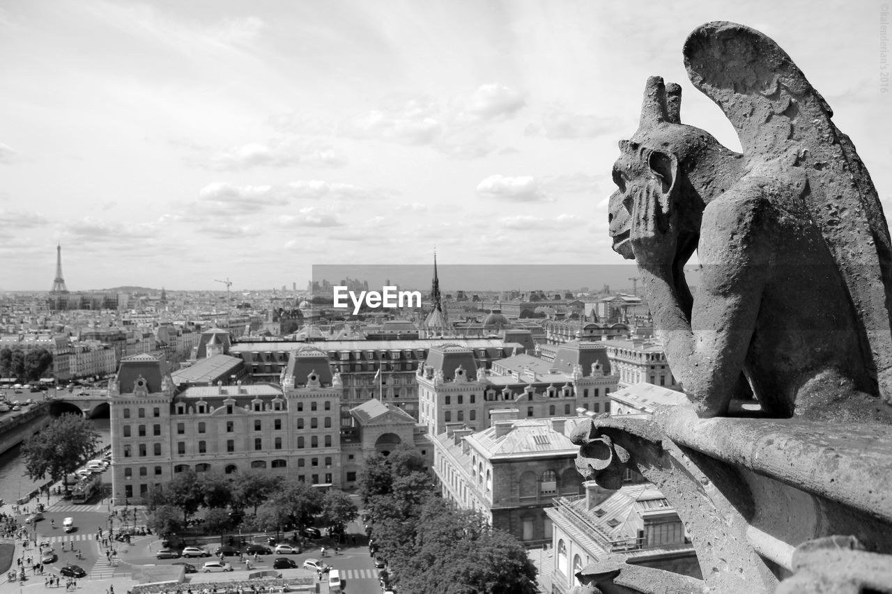 STATUE IN CITY AGAINST SKY