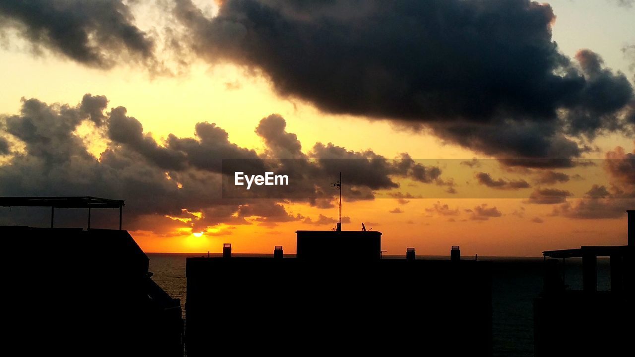 SILHOUETTE BUILDINGS AGAINST DRAMATIC SKY