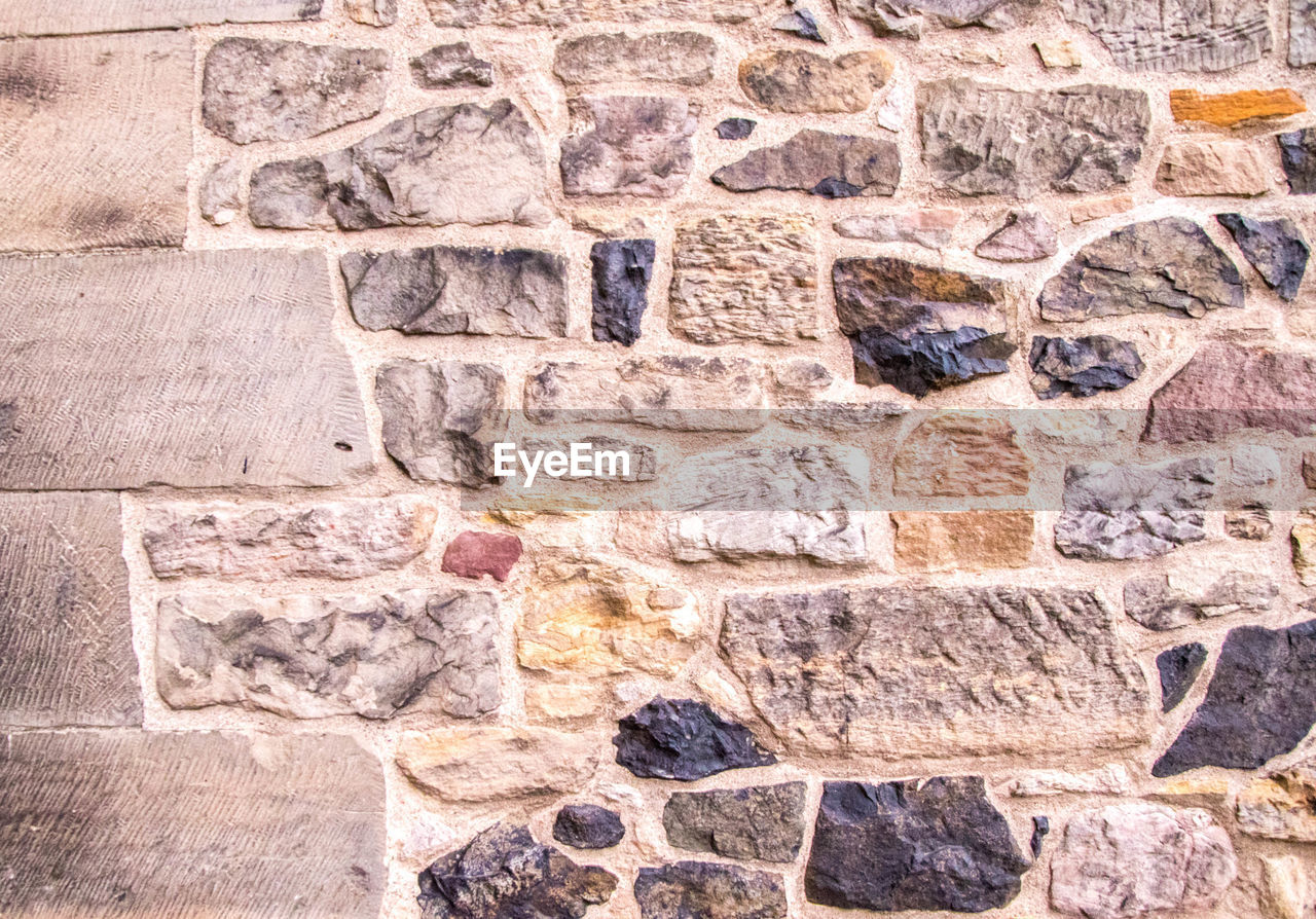 FULL FRAME SHOT OF STONE WALL WITH BRICK WALLS