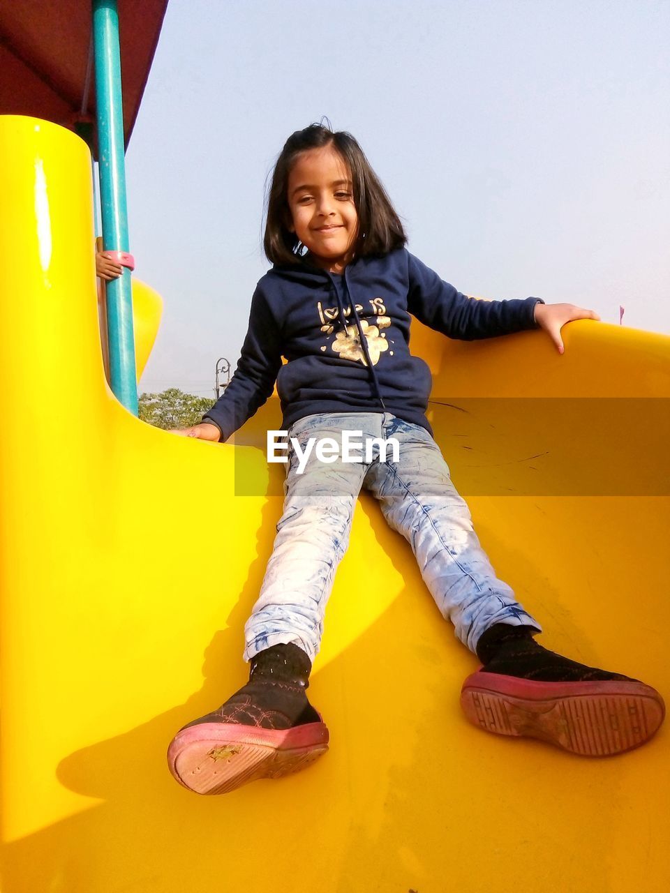 PORTRAIT OF HAPPY GIRL ON PLAYGROUND