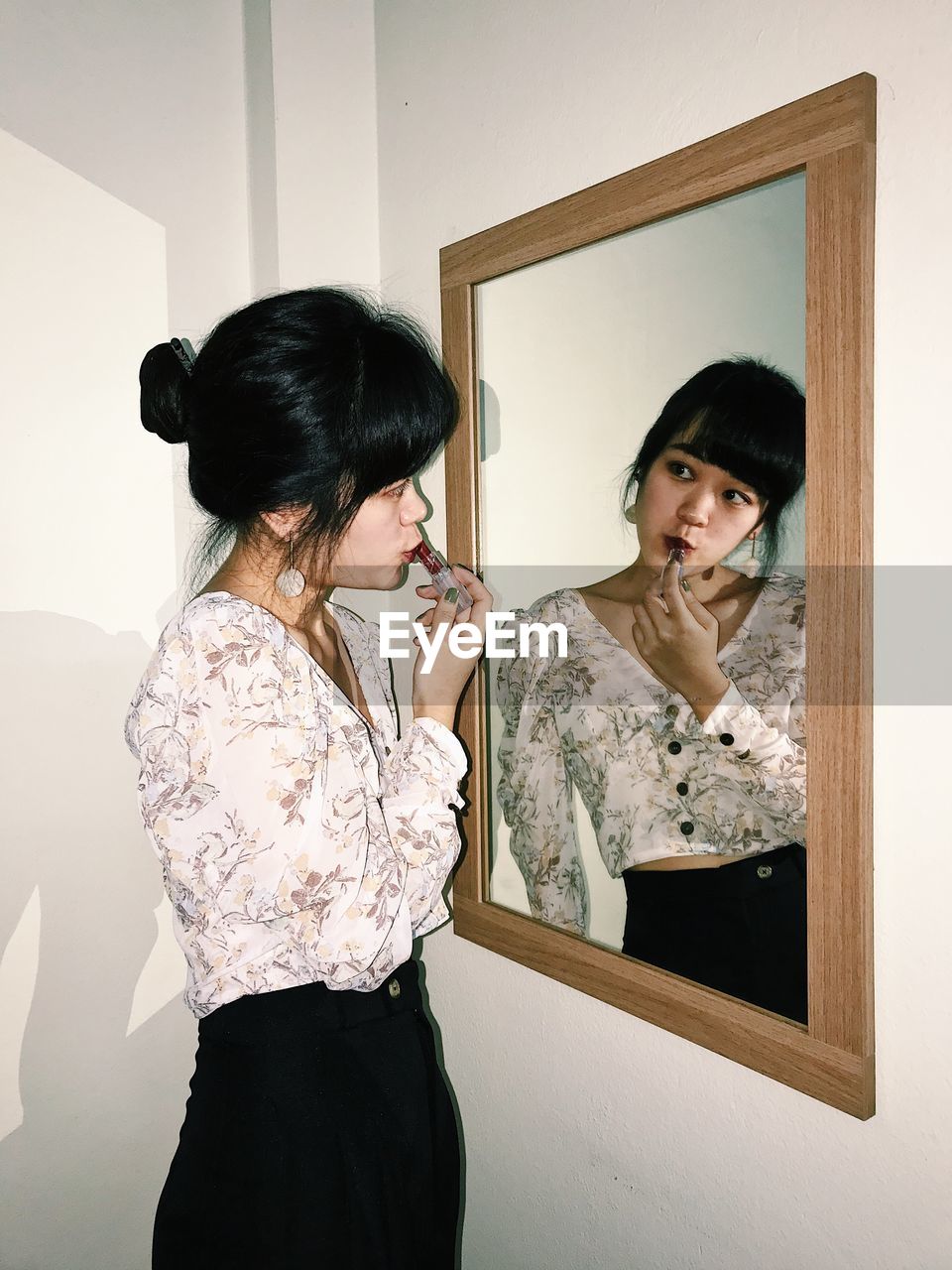 YOUNG WOMAN WITH REFLECTION IN MIRROR