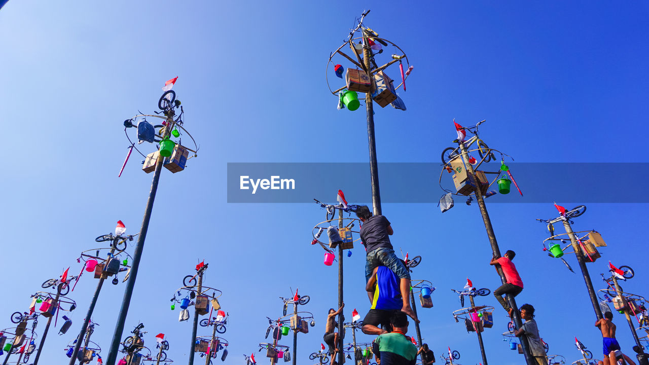 LOW ANGLE VIEW OF PEOPLE AGAINST CLEAR SKY