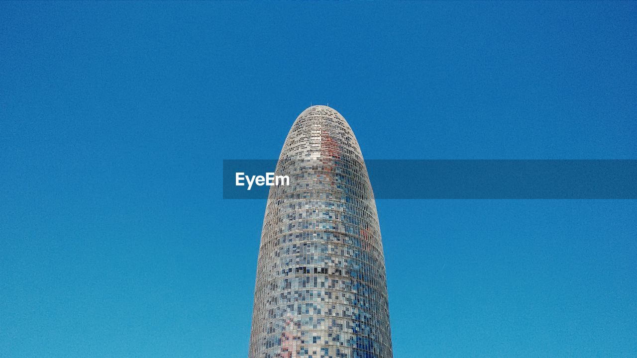 Low angle view of modern building against clear blue sky