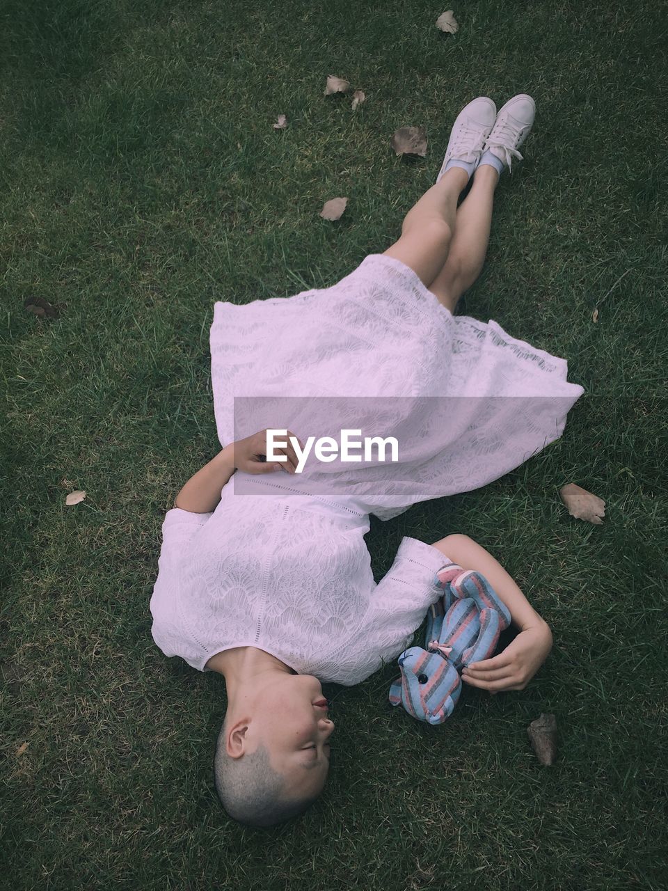 High angle view of girl lying on grassy field