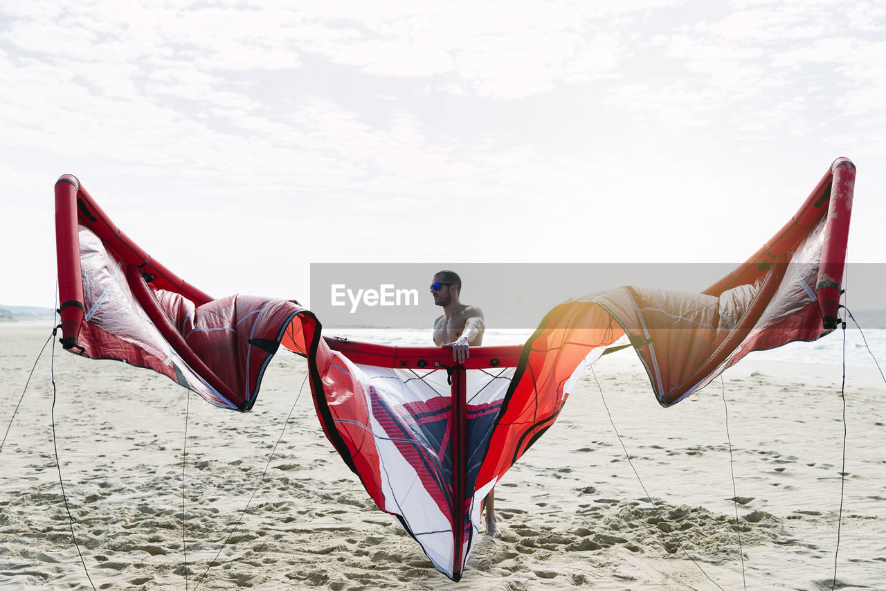 low angle view of woman standing at beach against sky