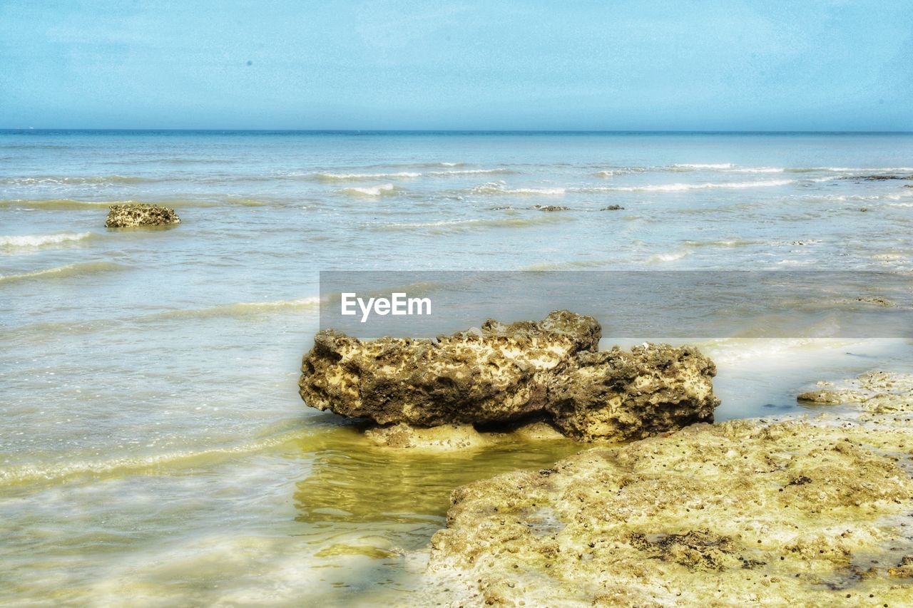 ROCKS ON SHORE AGAINST SKY