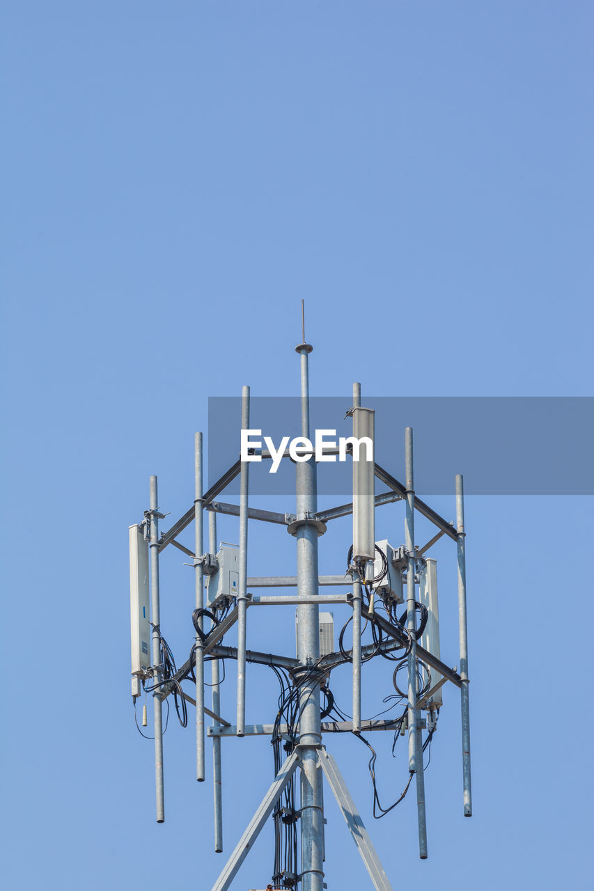 Low angle view of communications tower against clear blue sky