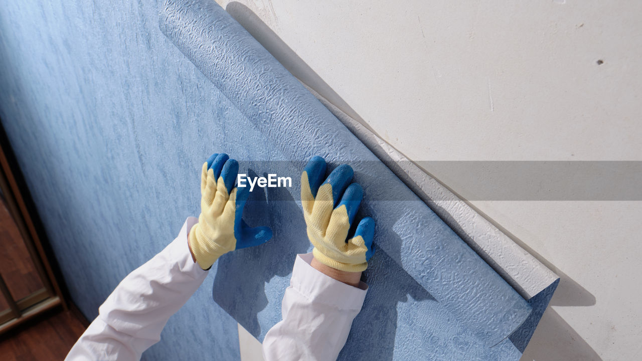 HIGH ANGLE VIEW OF HUMAN HAND ON WHITE WALL