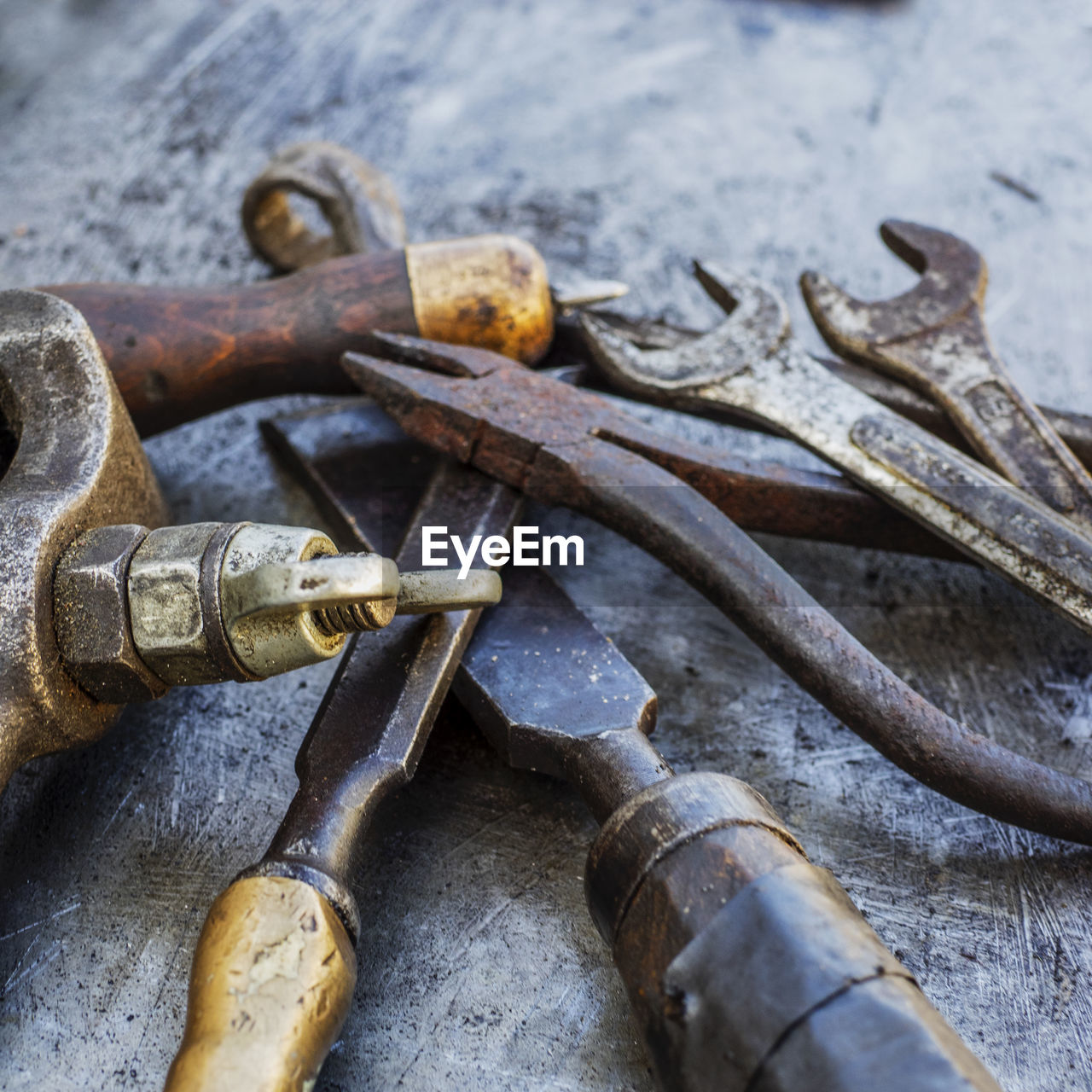Close-up of various rusty tools on metal table