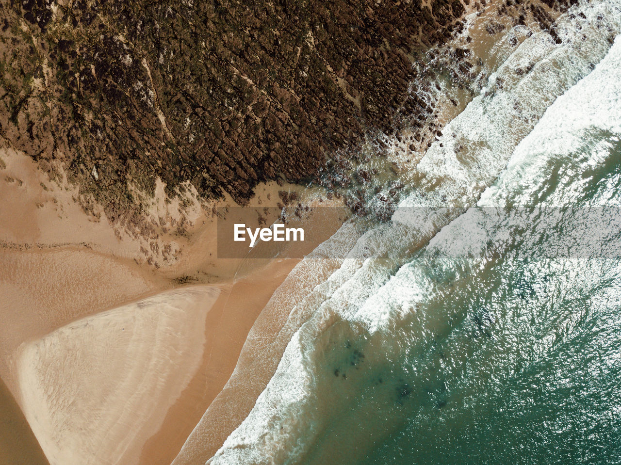 Top down scenic drone view of sea shore, beach and rocks