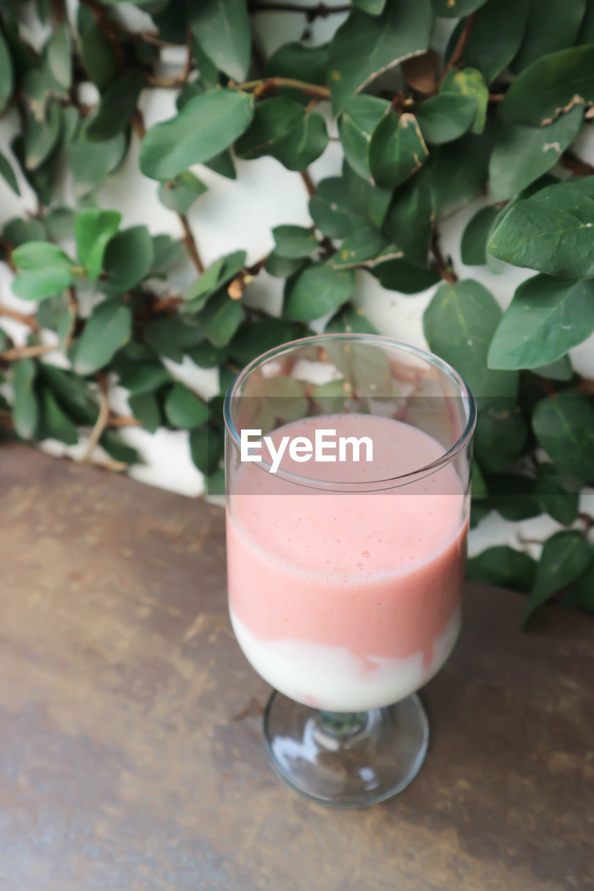 HIGH ANGLE VIEW OF DRINK ON GLASS TABLE