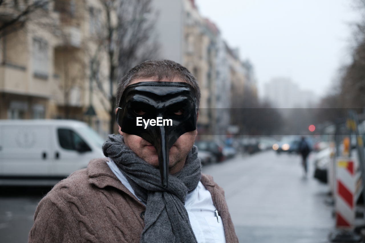 Portrait of man wearing mask on street in city