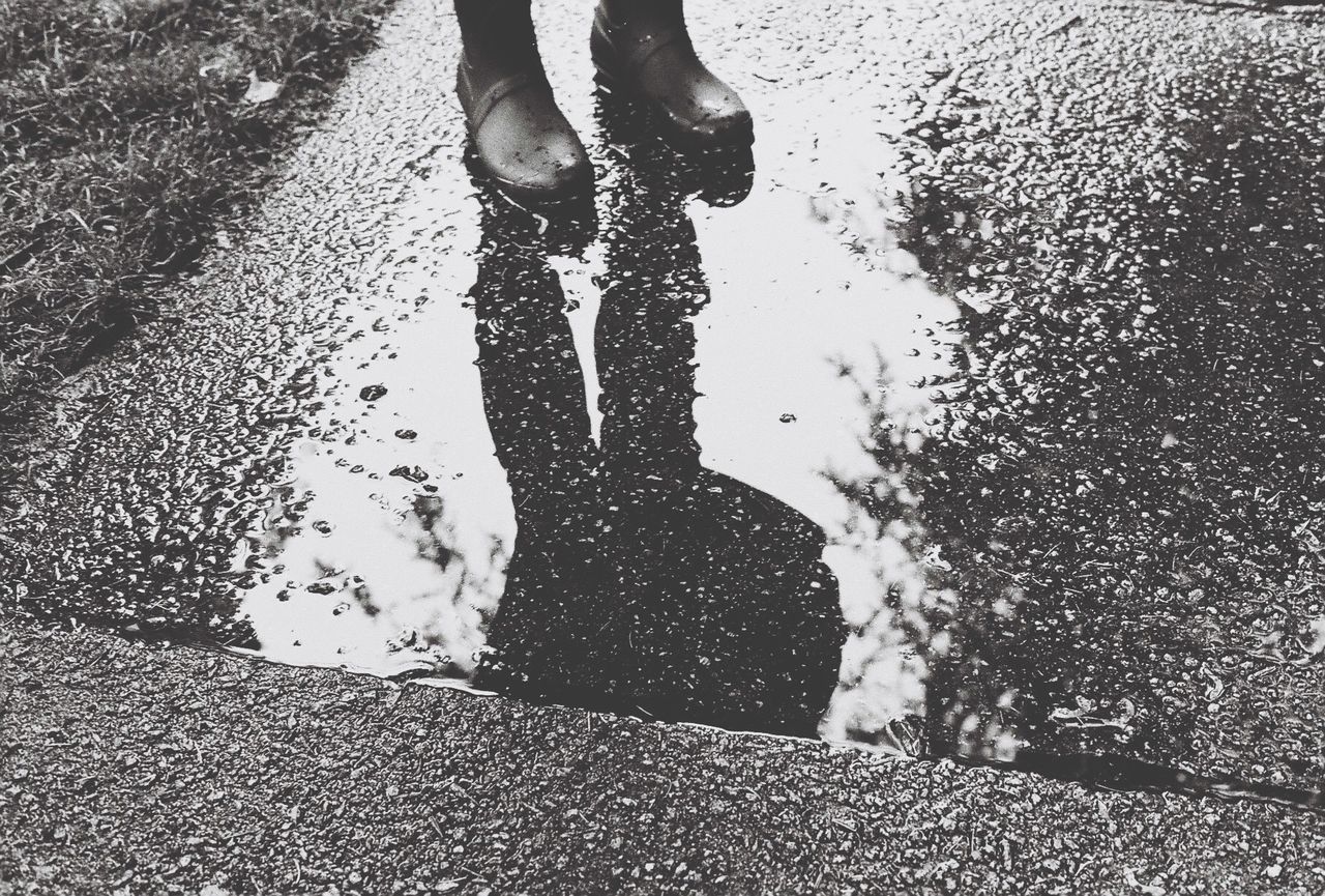 Low section of person standing on puddle