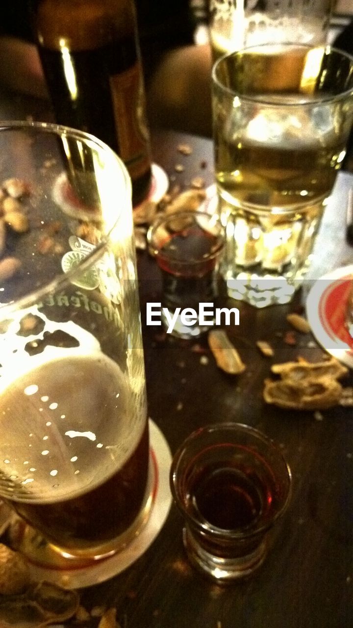 CLOSE-UP OF BEER IN GLASS ON TABLE