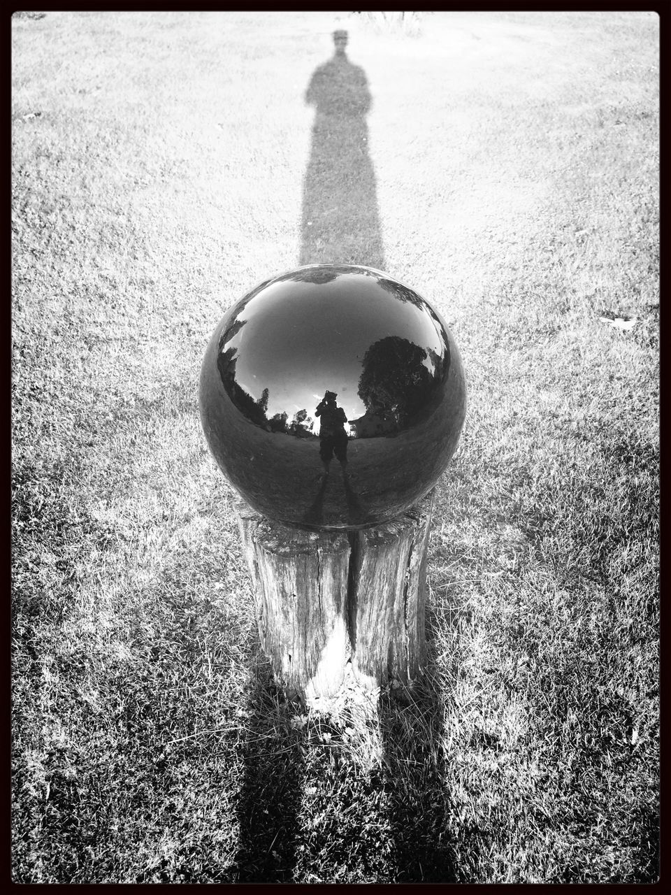 Reflection of man on black ball