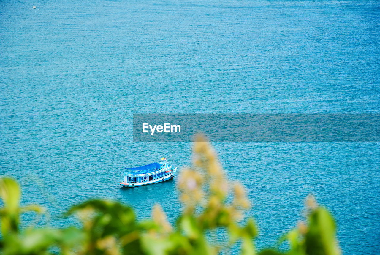 HIGH ANGLE VIEW OF SAILING BOAT IN SEA