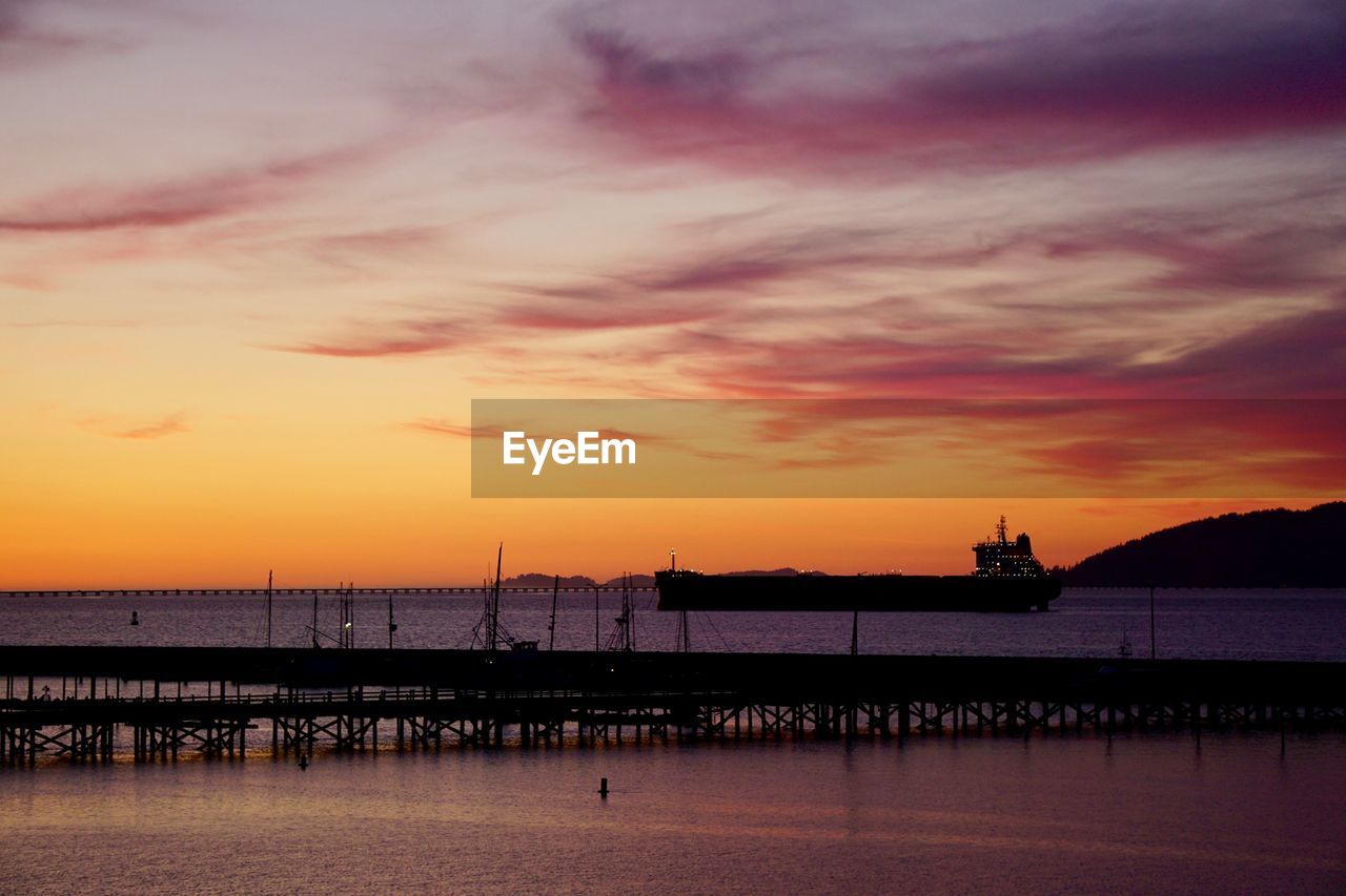 SILHOUETTE PIER ON SEA AGAINST SKY DURING SUNSET