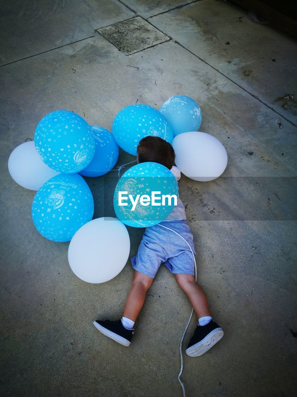 Rear view full length of boy playing with balloons on floor