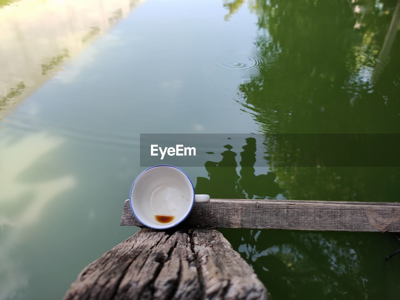 CLOSE-UP OF COFFEE CUP ON WOODEN POST