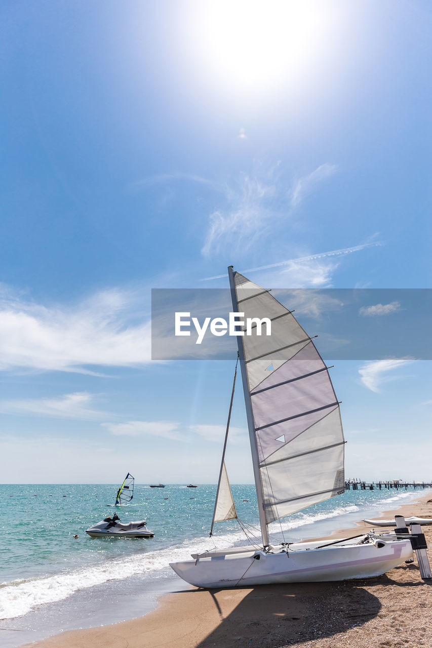 SAILBOATS MOORED ON SEA AGAINST SKY