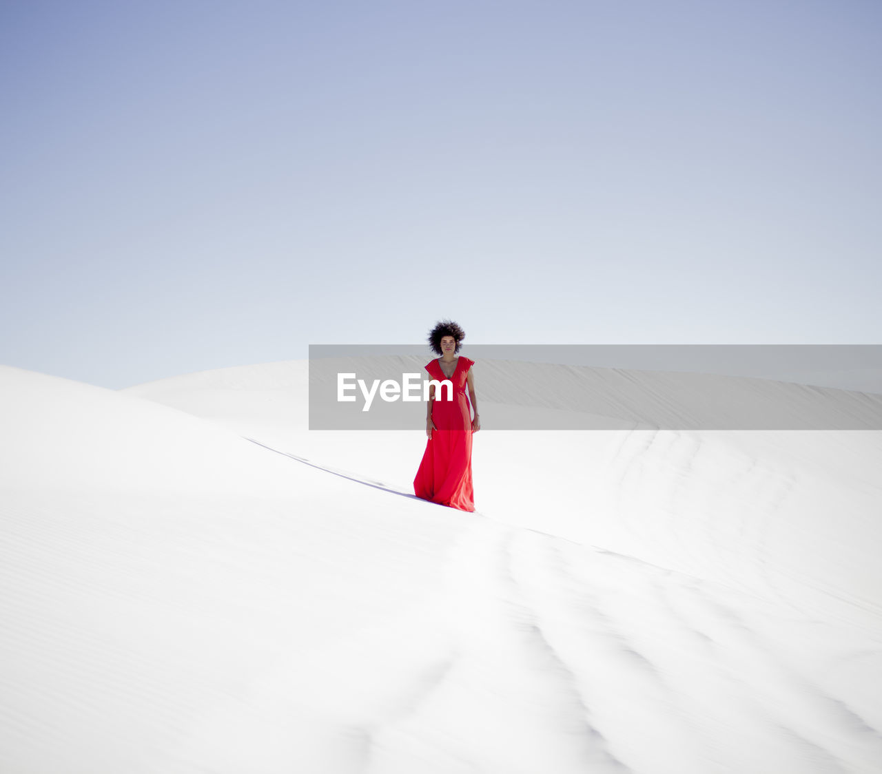 MAN STANDING ON SNOW COVERED LANDSCAPE