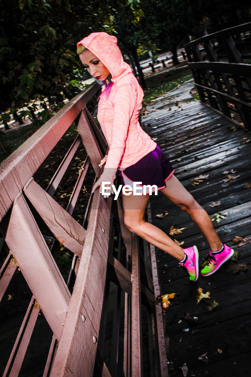 Tilt shot of woman standing on footbridge