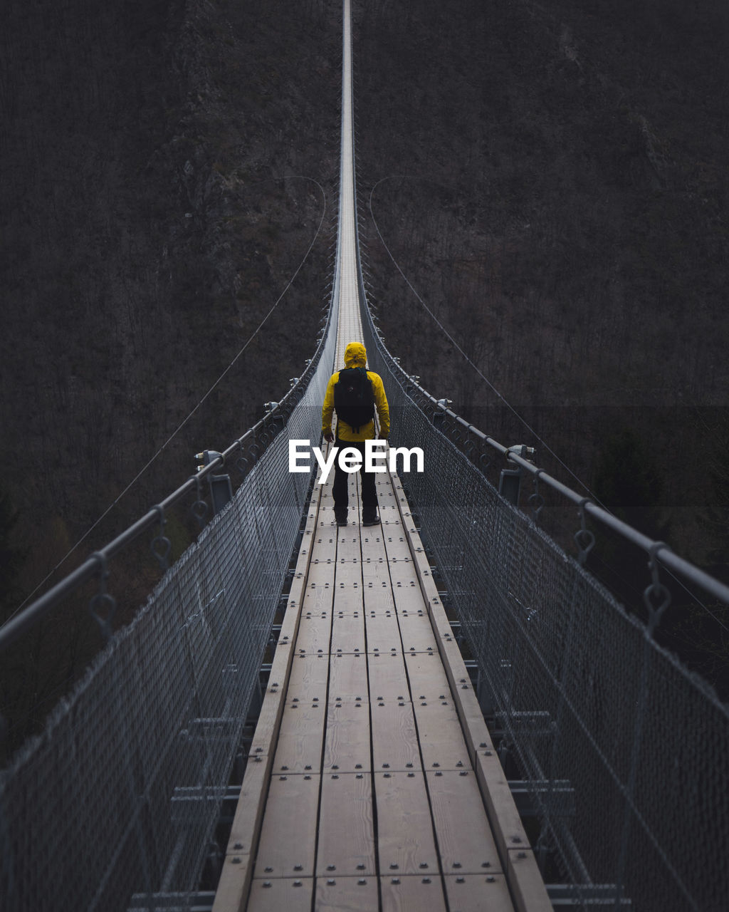 Man standing on footbridge
