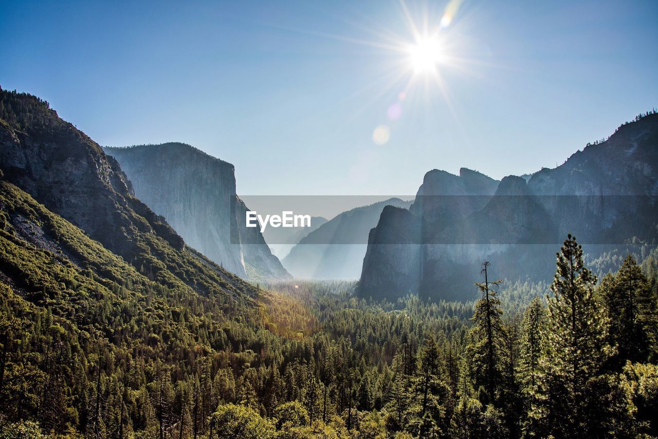 Scenic view of mountains against bright sun in yosemite national park