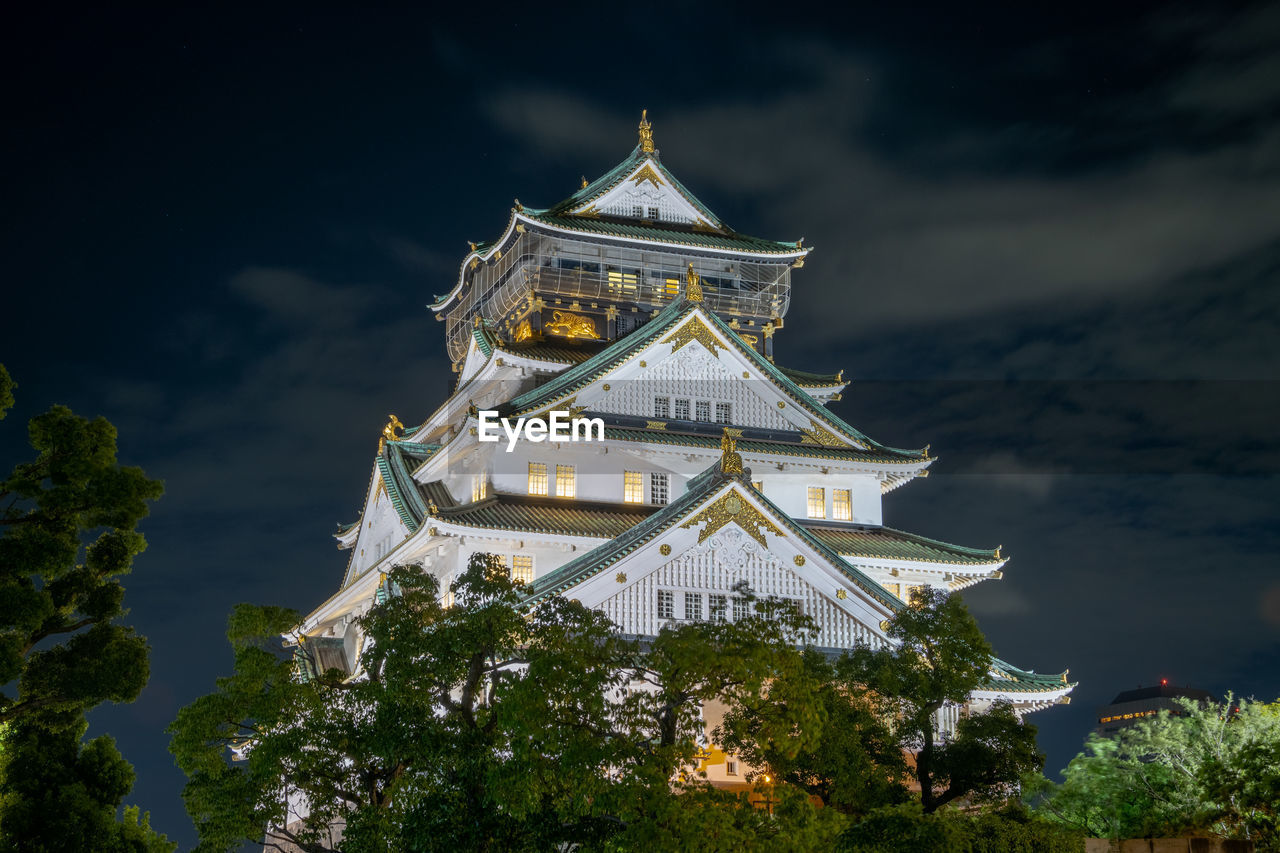 LOW ANGLE VIEW OF ILLUMINATED BUILDING AT NIGHT