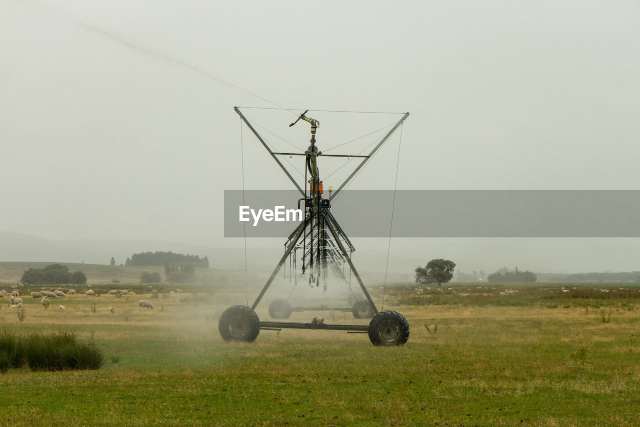 WIND TURBINES IN FIELD AGAINST CLEAR SKY