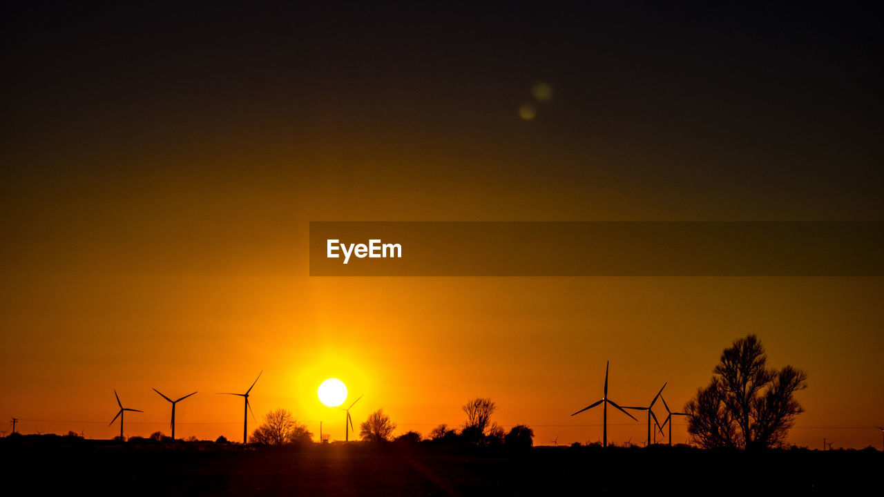 SILHOUETTE OF WINDMILL ON FIELD AGAINST SKY DURING SUNSET