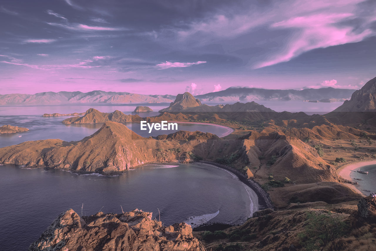 Scenic view of sea and mountain against cloudy sky