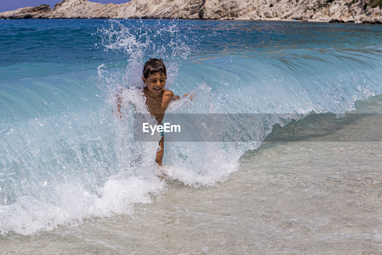 Little kid enjoying the waves on the beach