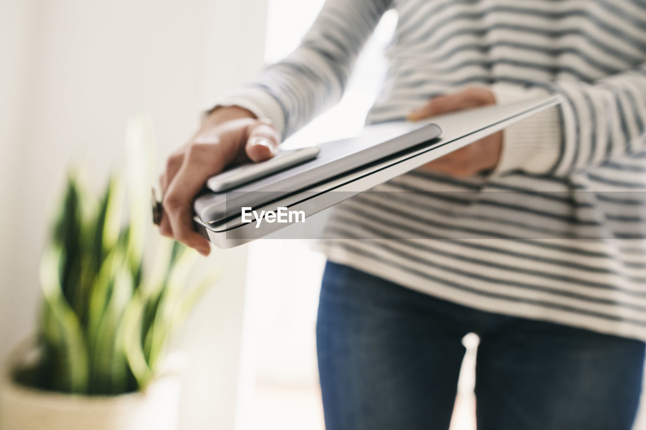 Woman holding portable devices in different sizes