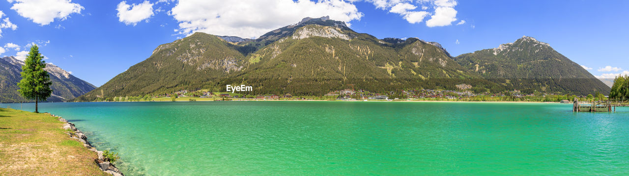 Panoramic view of lake and mountains against blue sky