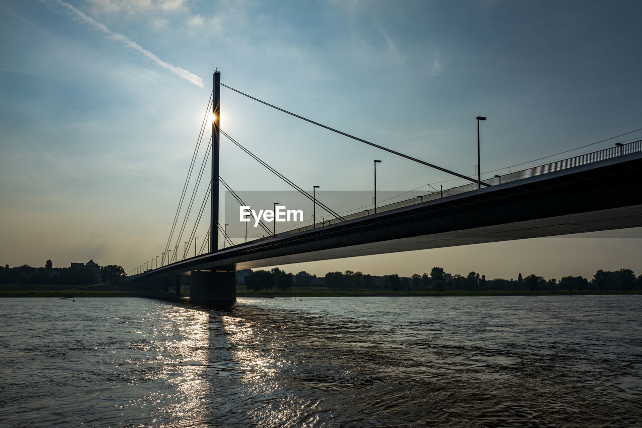 Bridge over river against sky during sunset