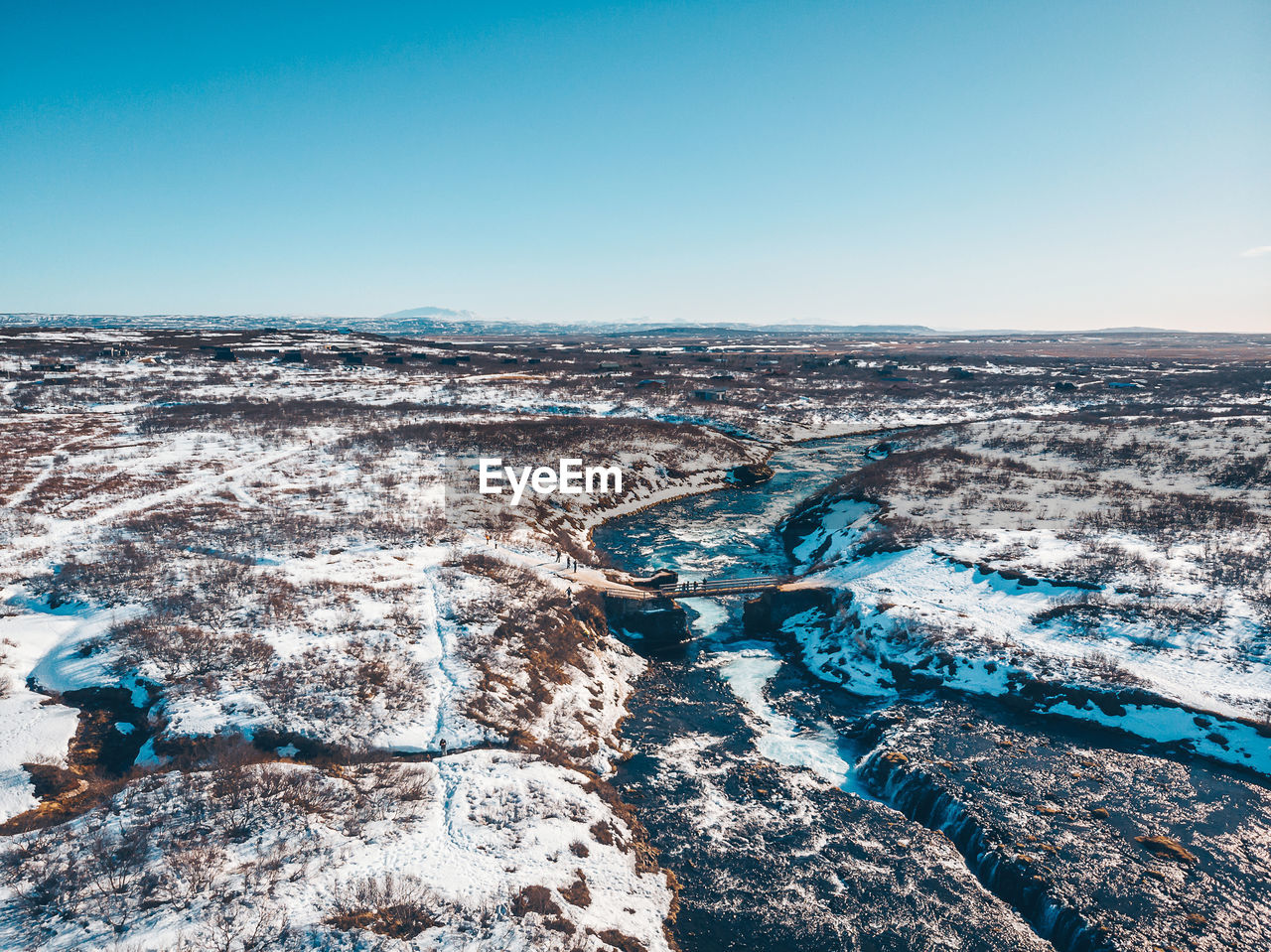 Aerial view of snow covered landscape against clear sky